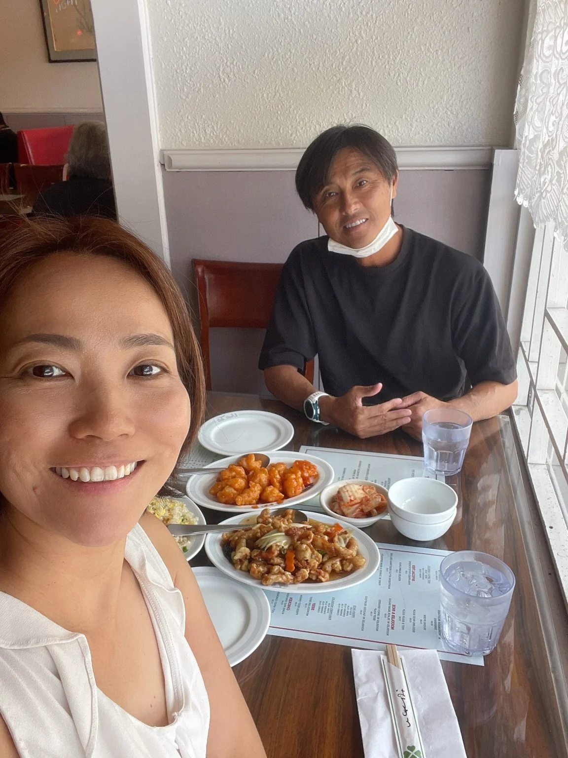 中華料理の並ぶテーブルで笑顔の2人