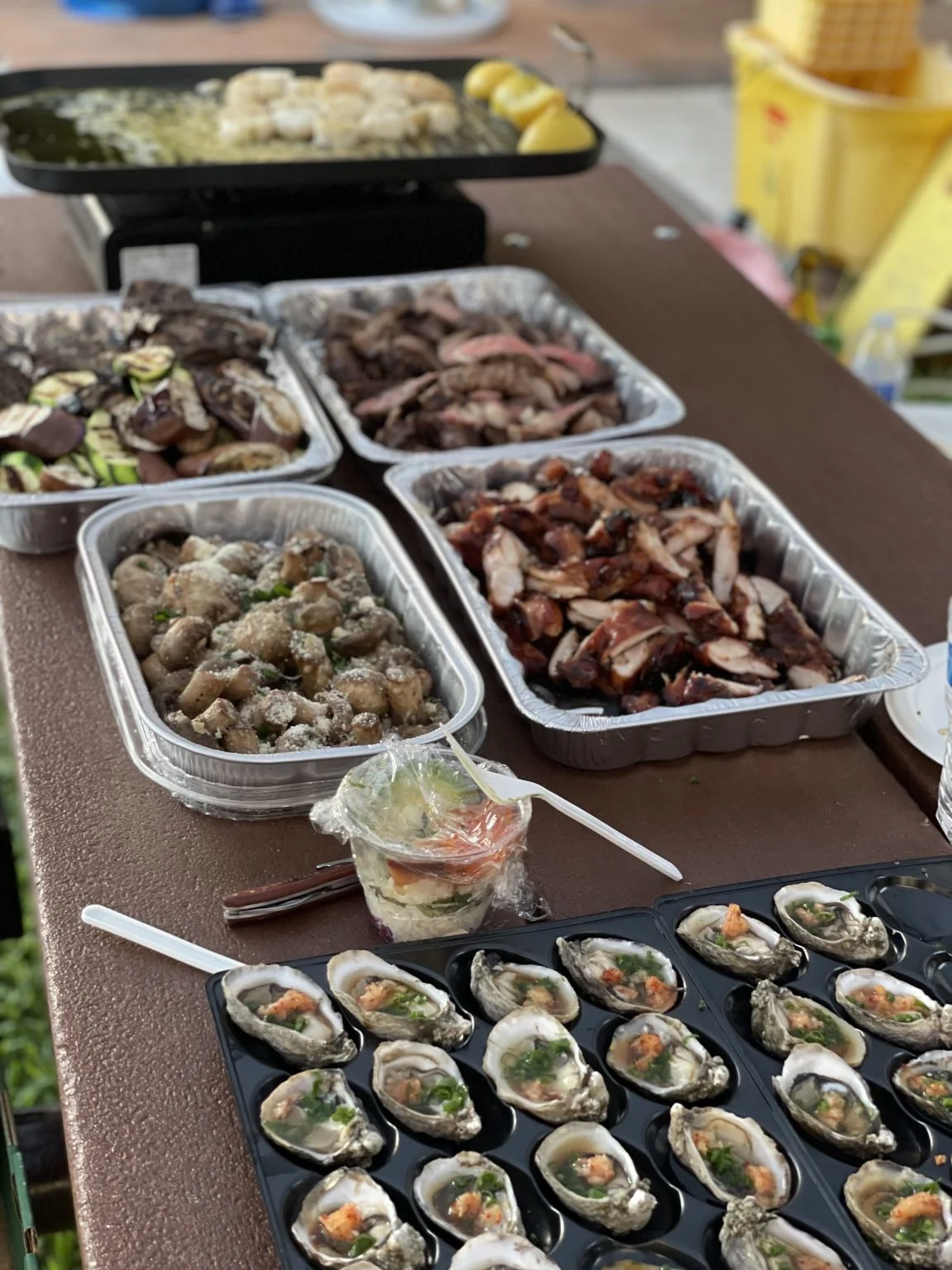 テーブルに並ぶ焼き牡蠣や肉などのBBQ料理