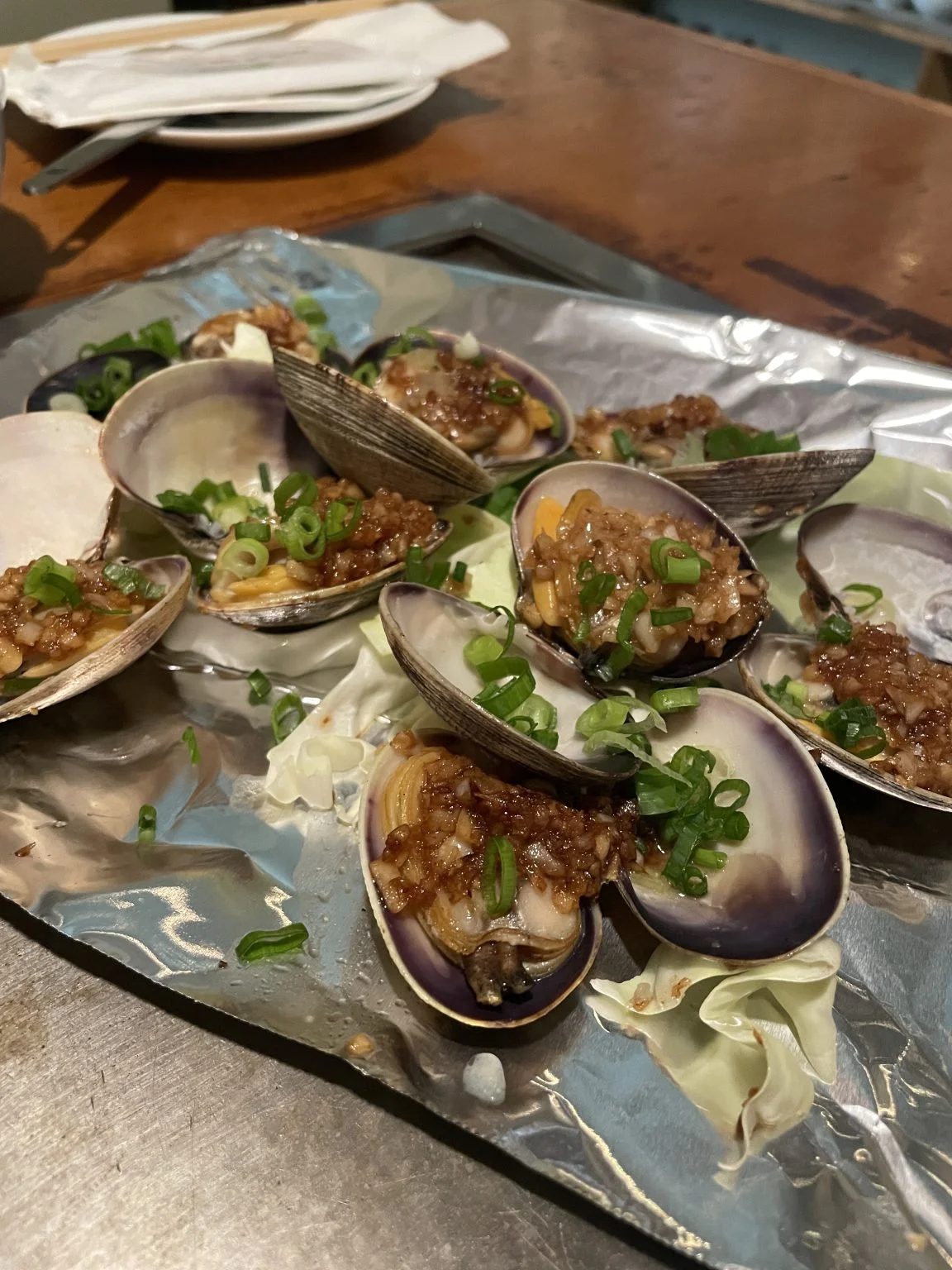 アルミホイルの上で焼いた貝のねぎ醤油