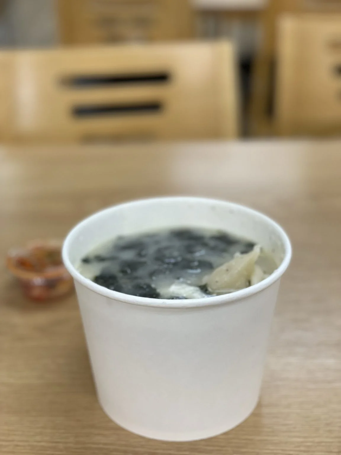 紙カップのスープと小さなキムチ