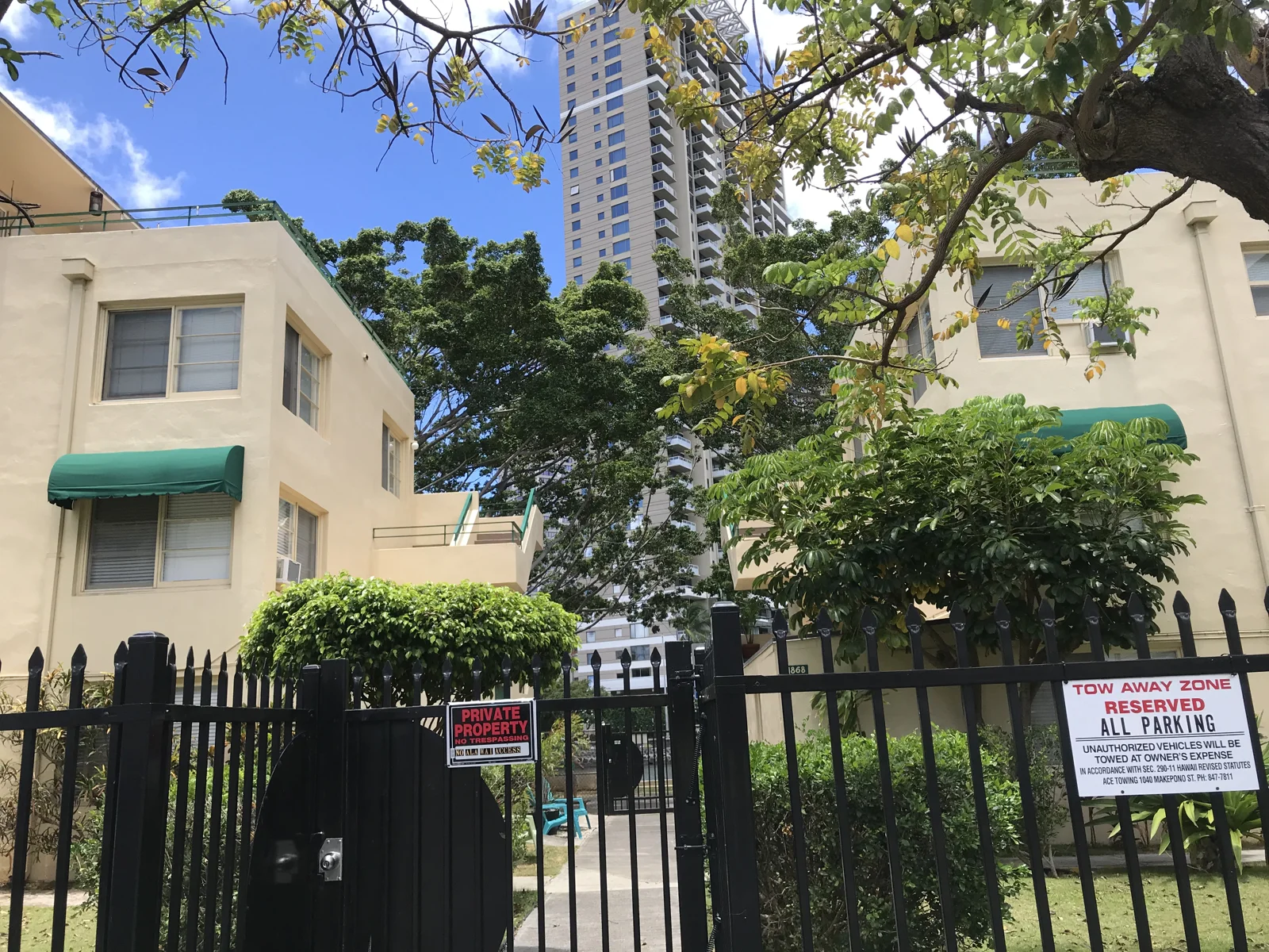 フェンス越しに見る緑に囲まれた低層の建物