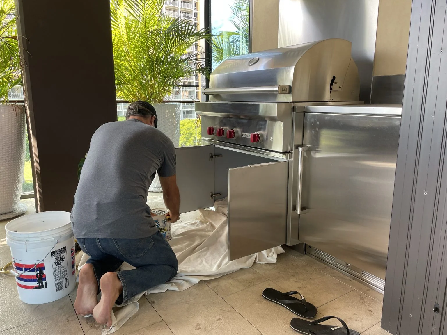 屋外キッチンのグリル周りを修理する作業員