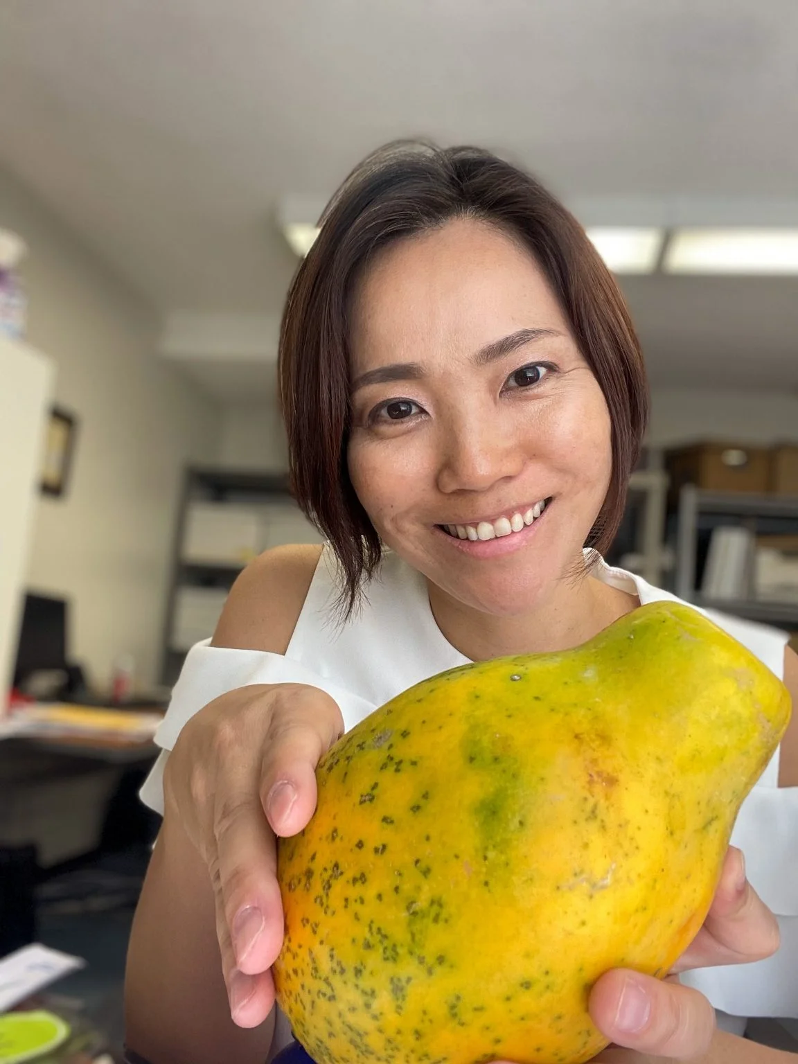 大きなパパイヤを手に持つ笑顔の女性