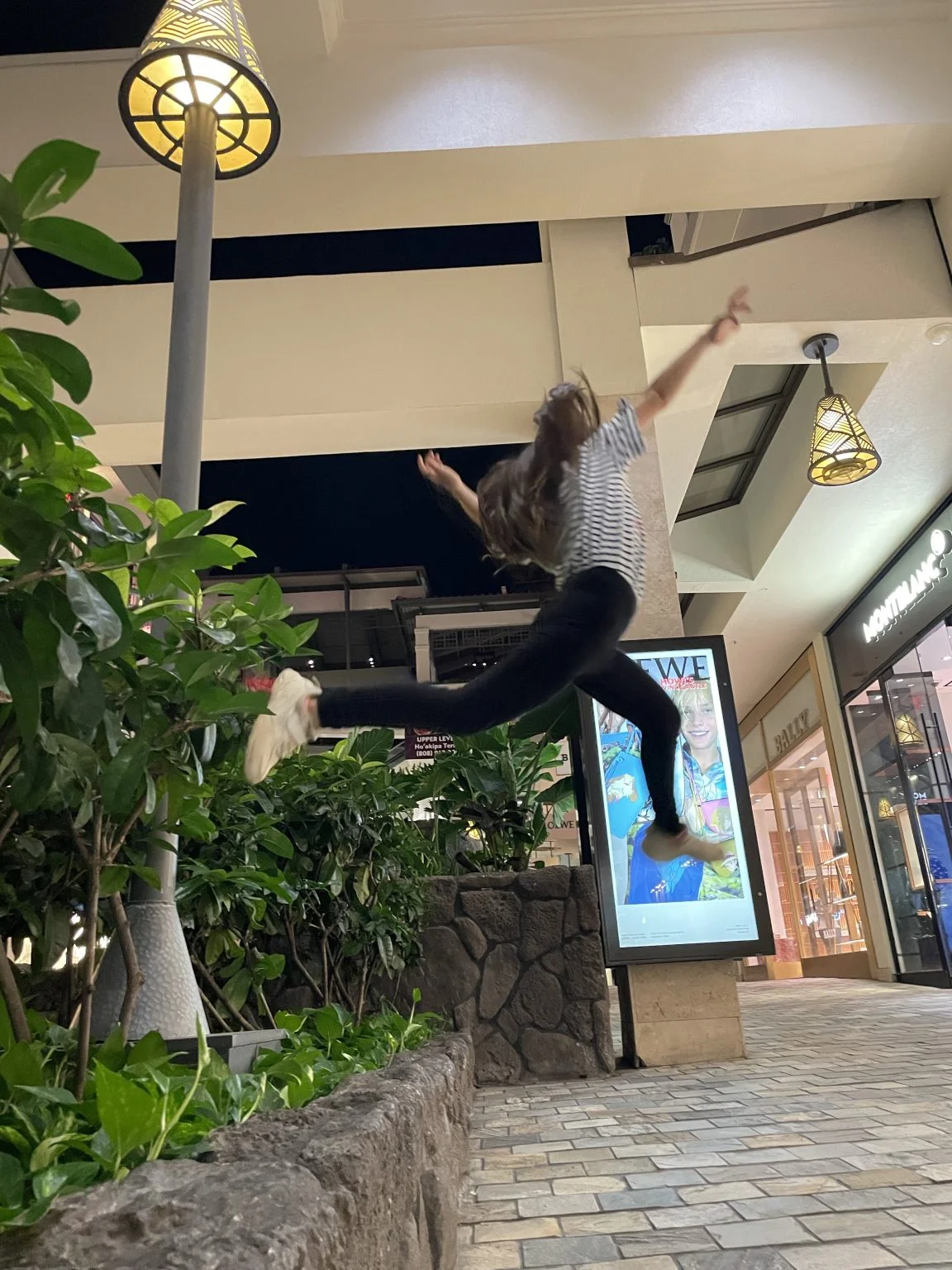 夜のモールの通路で高くジャンプする人