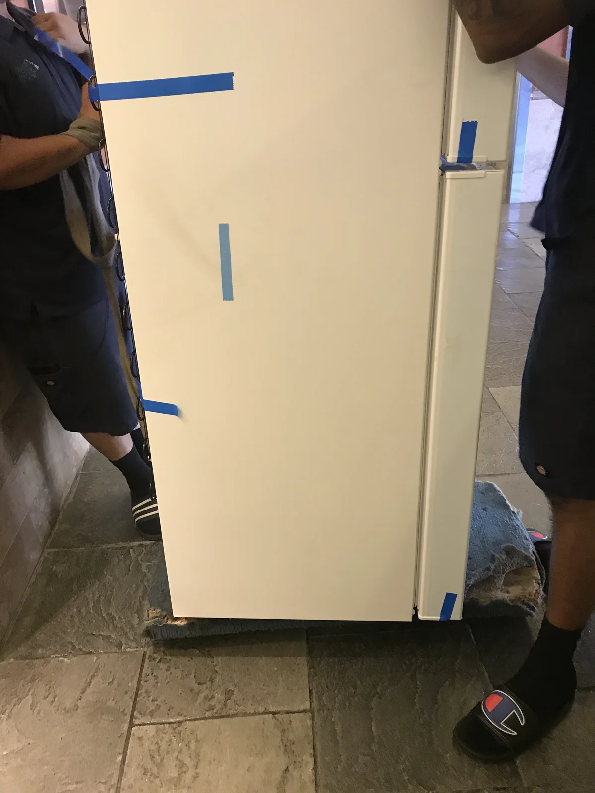 作業員が運び出す冷蔵庫