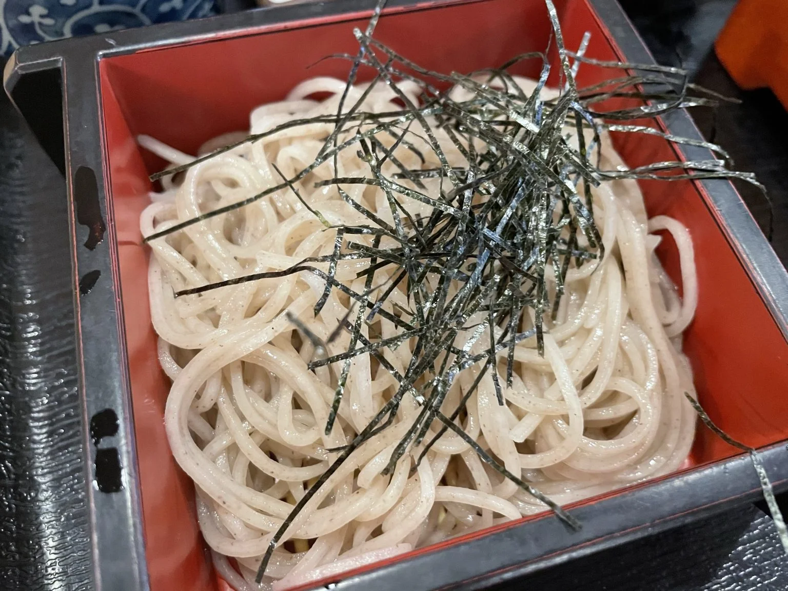 刻み海苔をのせた器盛りの冷たいそば