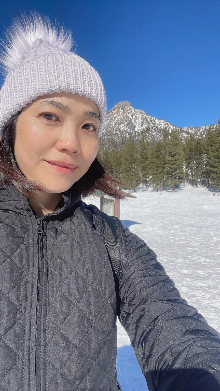 雪山を背にニット帽をかぶった女性のセルフィー