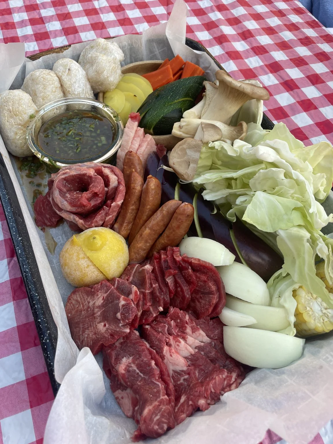 トレーに盛ったBBQ用の牛肉、ソーセージ、野菜