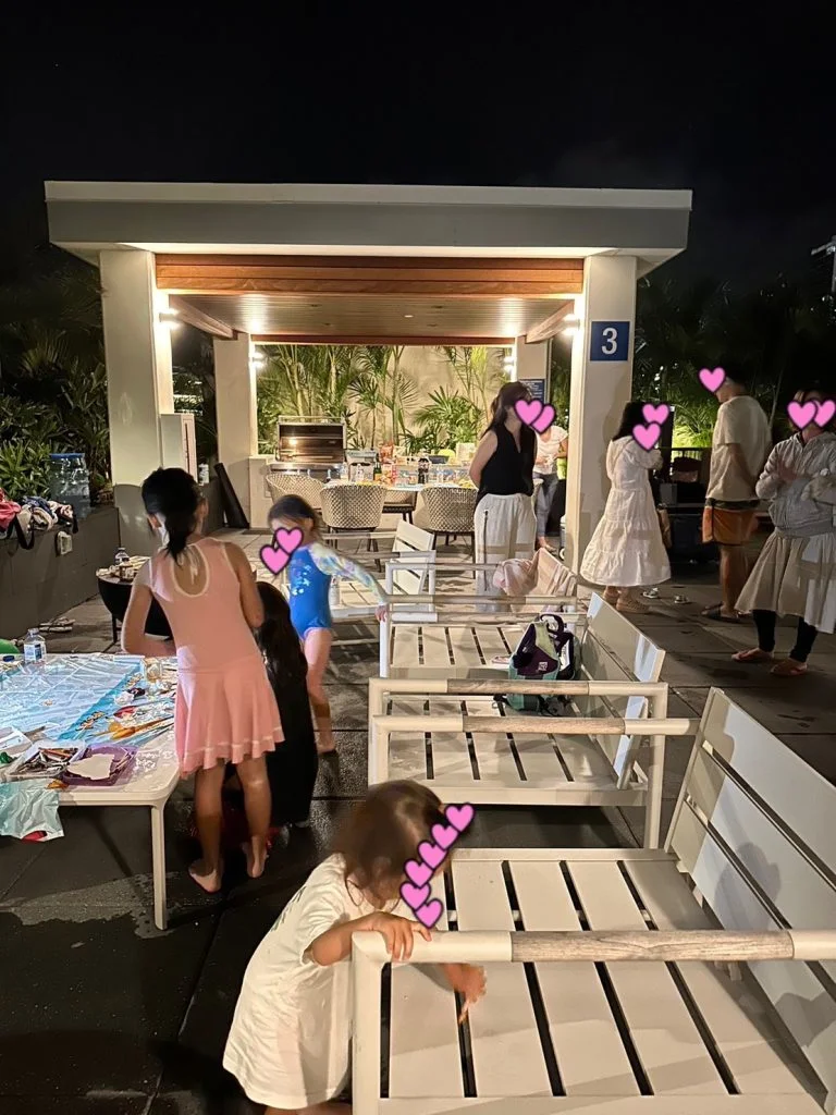 夜のプールデッキのカバナで誕生日会を楽しむ子どもたち