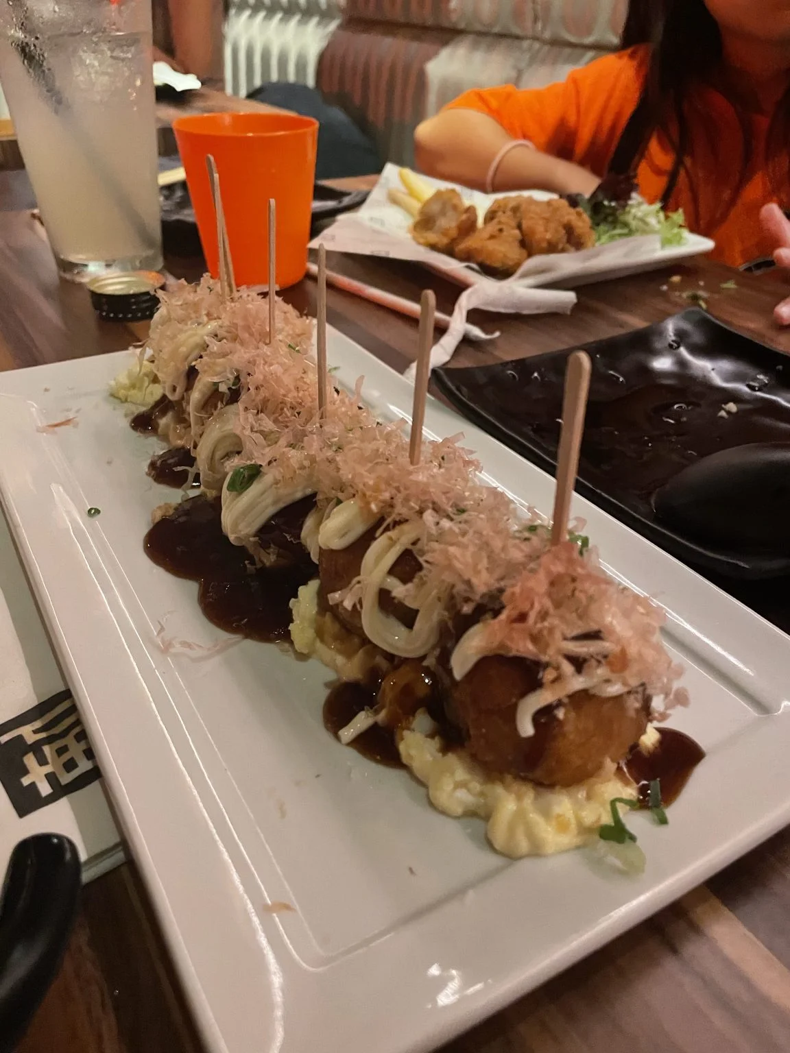 かつお節とソースがかかった串刺しのたこ焼き