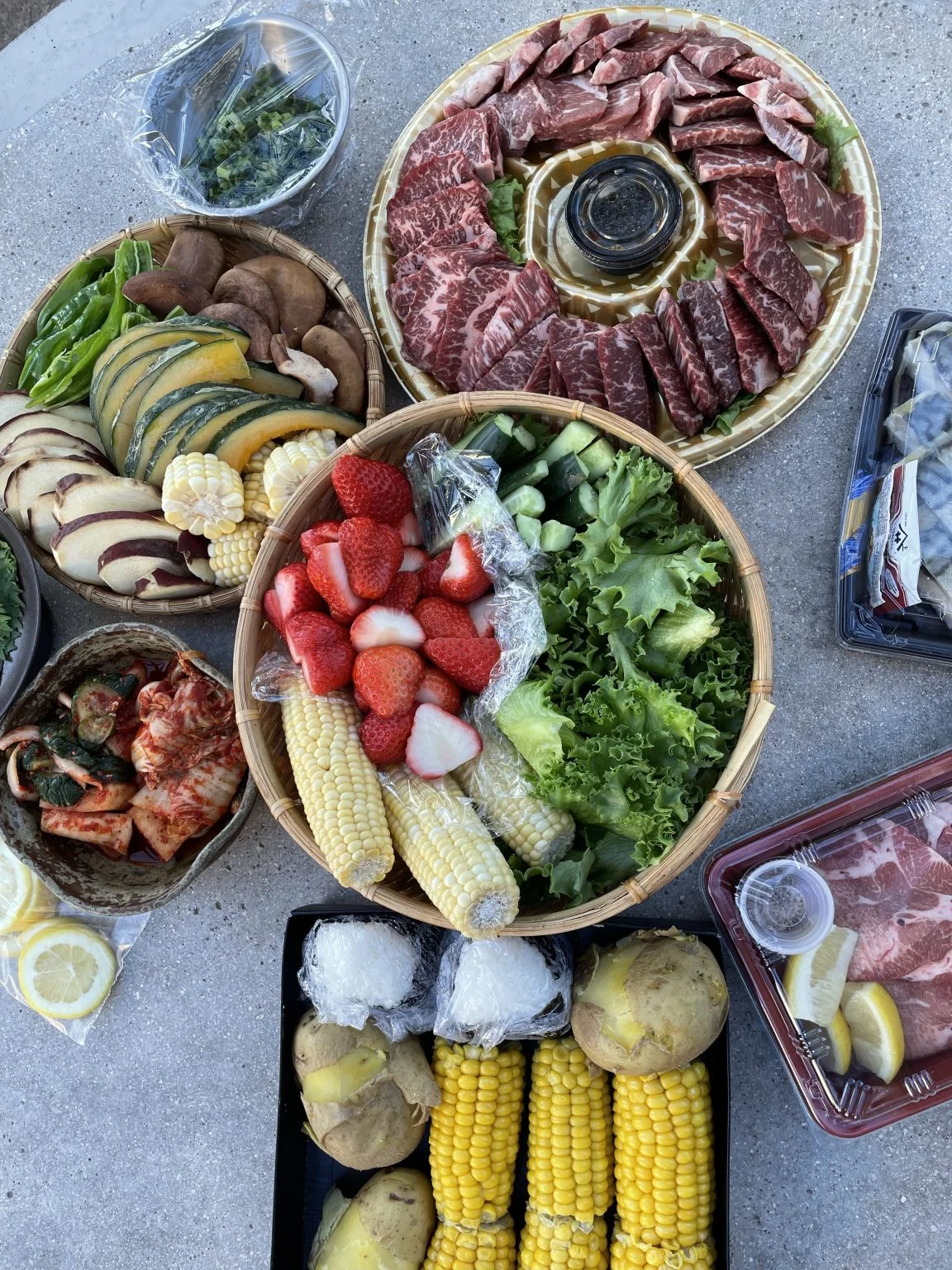 テーブルに並ぶ焼肉用の肉と野菜、果物